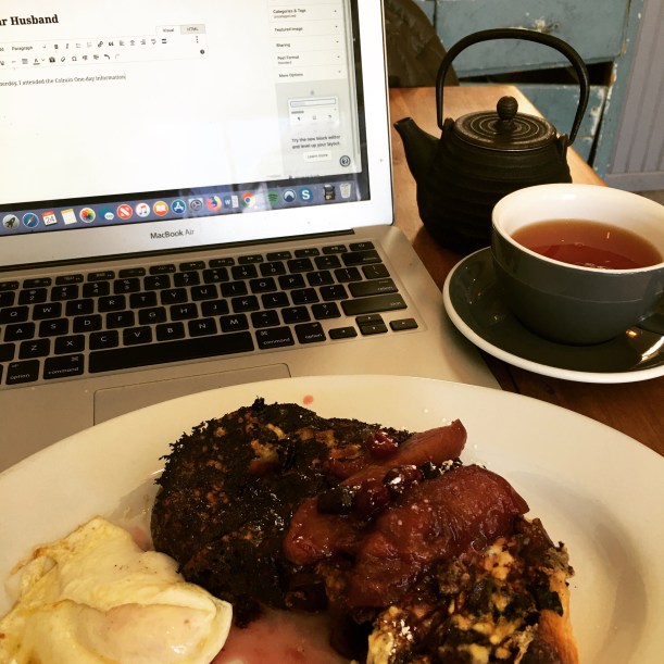 Plate of french toast and fried egg in the foreground; open laptop in the background with cup of Earl Grey tea and teapot
